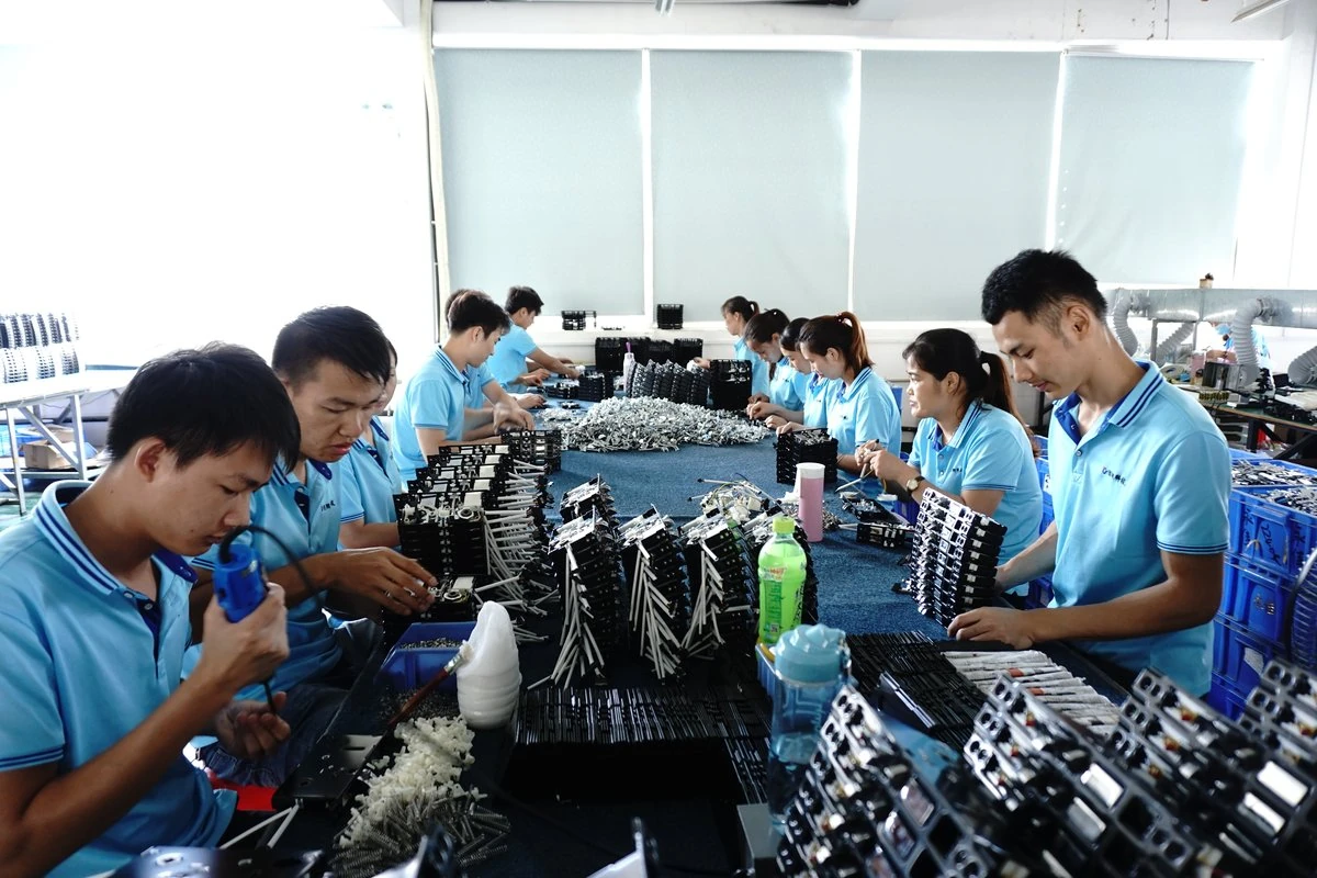 Workers assembling smart lock components at an assembly station